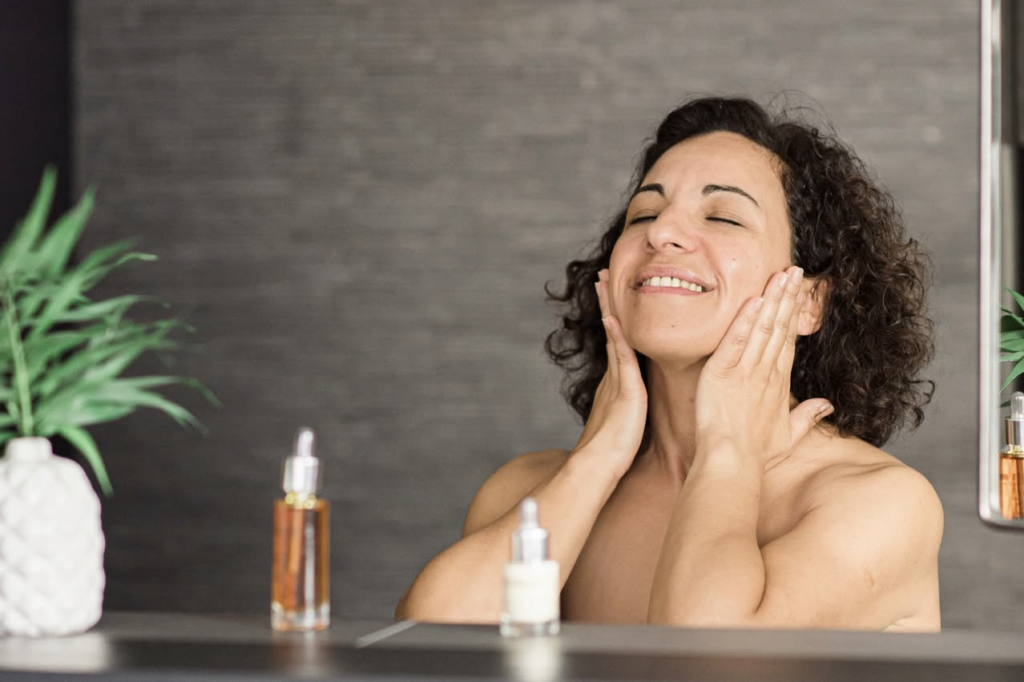 Femme appliquant un soin visage, routine hydratation peau mature après 40 ans